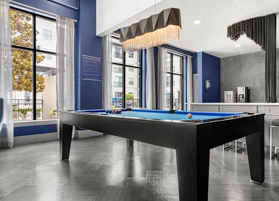 A pool table in a room with a blue wall.