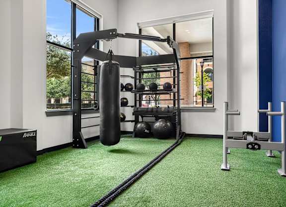 A gym with a green carpet and a punching bag.