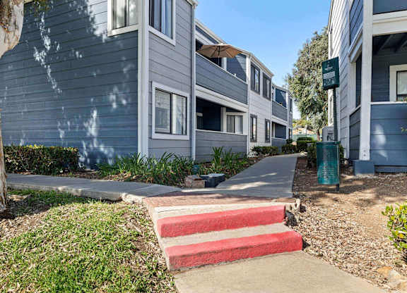 A row of houses with a red and white staircase in the foreground.