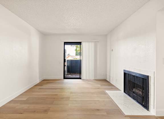 A room with a fireplace and a sliding glass door.