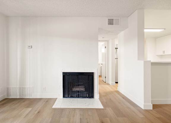 A large, empty room with a fireplace at the center.