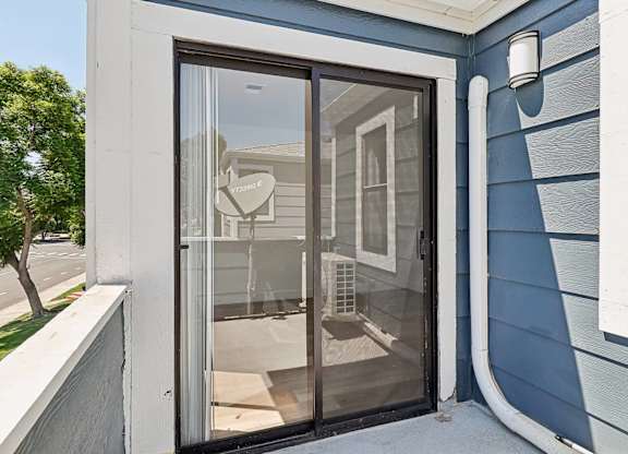 A blue house with a glass door and a sign that says "Welcome".