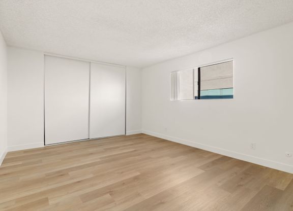 A room with a white wall and a wooden floor.