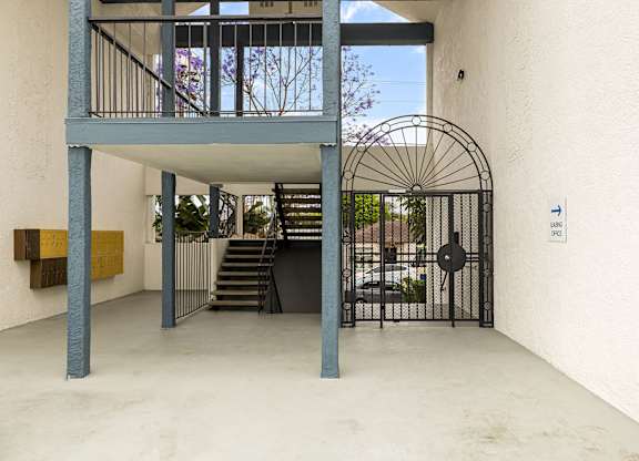 A white building with a gate and a staircase.