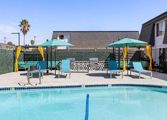 A pool with a blue line in the middle and a green umbrella.
