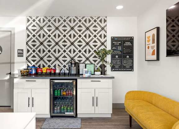 A kitchen with a yellow couch and a patterned wallpaper.