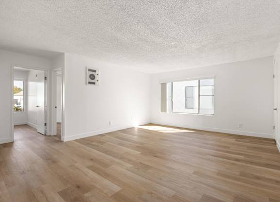 A room with wooden flooring and a window.