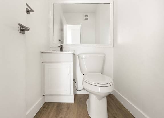 A white toilet and sink in a small bathroom.