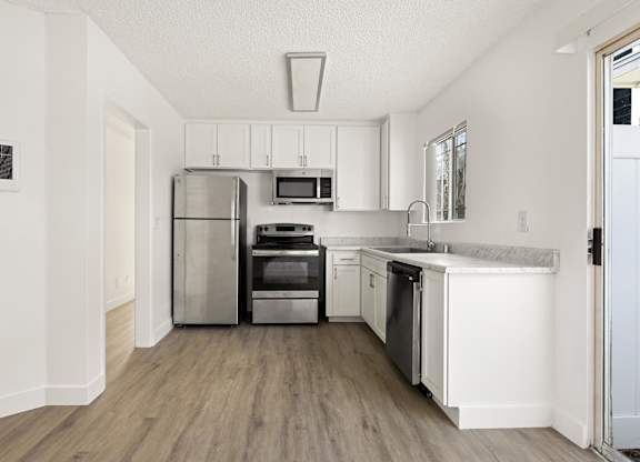 A modern kitchen with stainless steel appliances and white cabinets.