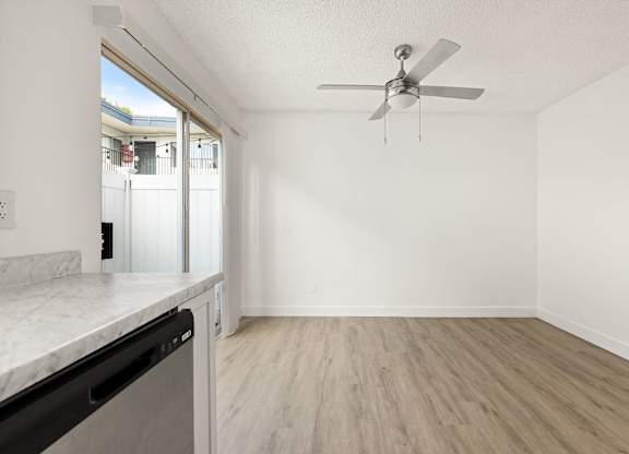 A room with a ceiling fan and a marble countertop.
