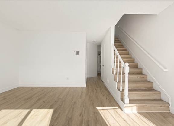 A room with a staircase leading to another room.