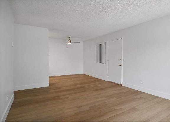 A room with wooden floors and white walls.