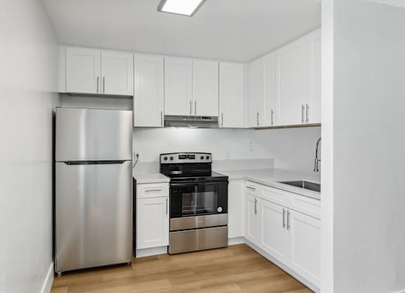 A kitchen with white cabinets and stainless steel appliances.