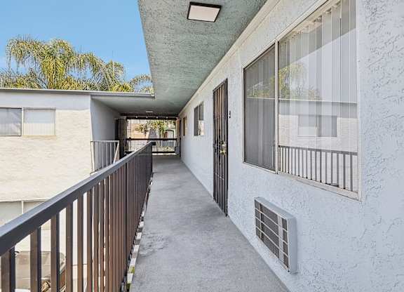 A balcony with a railing and a door with a window above it.