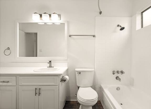 A white bathroom with a toilet, sink, and bathtub.