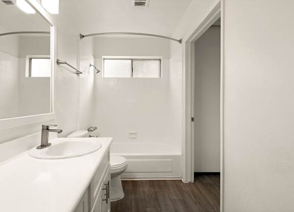 A white bathroom with a sink, toilet, and bathtub.