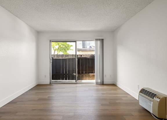 A room with a sliding door leading to a balcony.