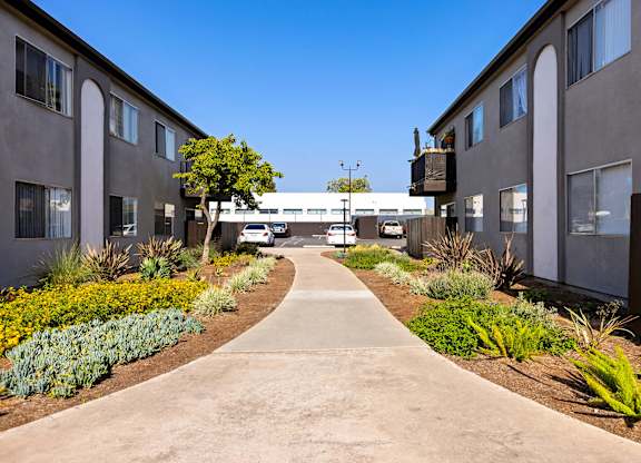 A concrete pathway leads between two rows of buildings.