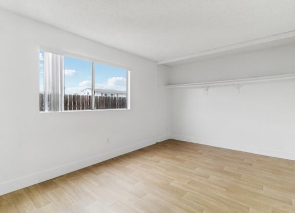 Empty room with wooden floor and a window.
