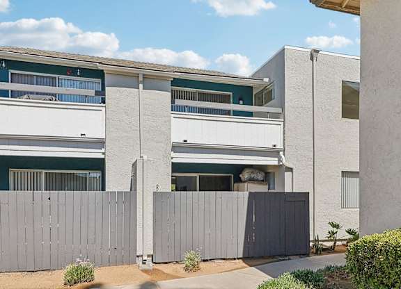 A modern building with a grey fence in front.