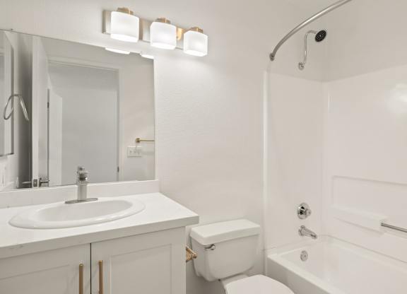 A white bathroom with a sink, toilet, and bathtub.