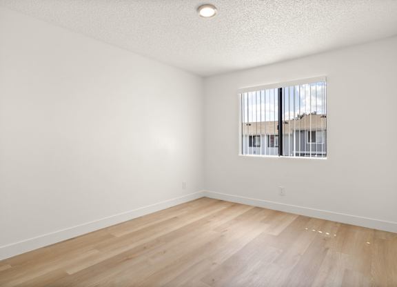Empty room with wooden floor and a window.