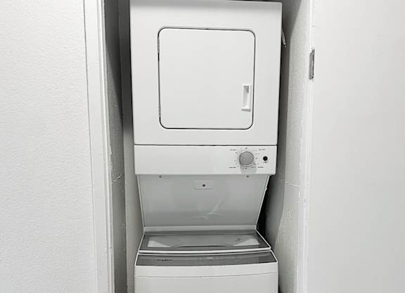 A white dishwasher is installed in a white wall.