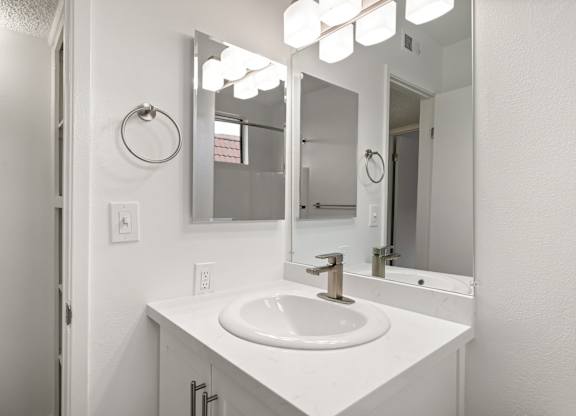 A white bathroom sink with a mirror above it.