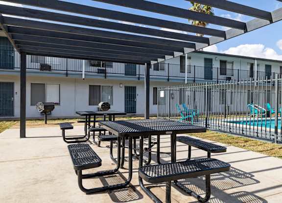 A black table and benches are set up under a black awning.