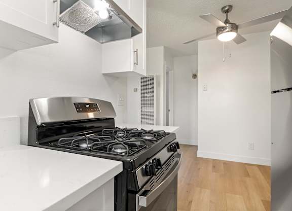 A modern kitchen with a stainless steel stove and white countertops.