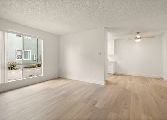 A room with wooden flooring and white walls.
