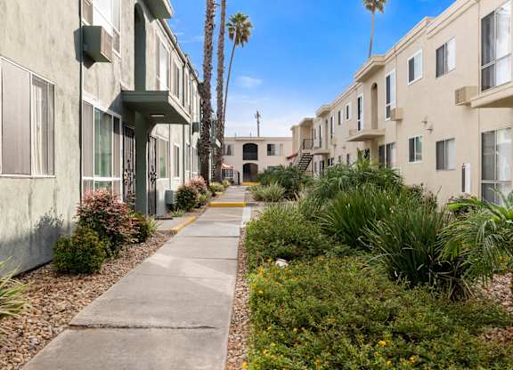 A row of houses with a concrete walkway between them.