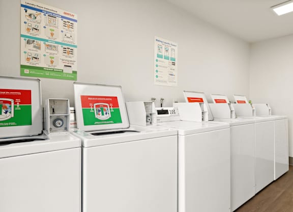 A row of washing machines are lined up in a laundromat.