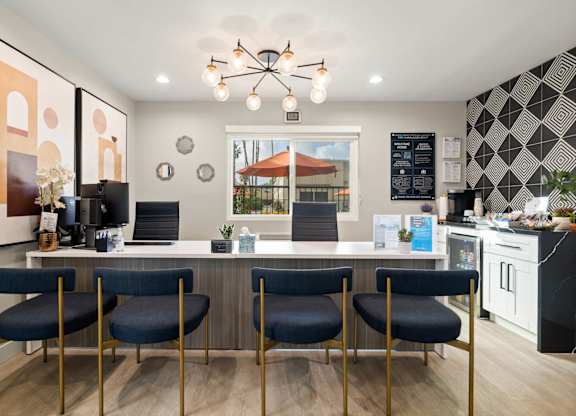 A modern kitchen with a bar area and chairs.