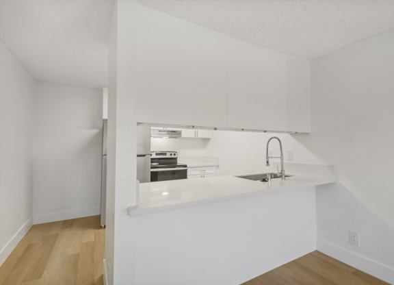 A kitchen with white cabinets and a sink.