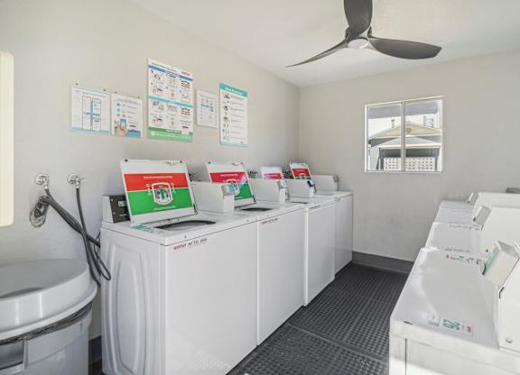 A row of washing machines are lined up in a laundromat.