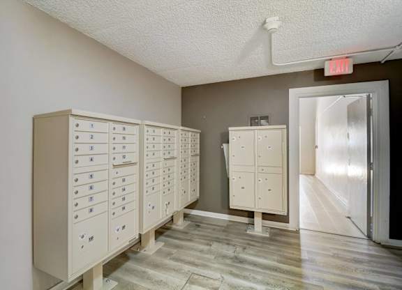 A room with a row of filing cabinets and a red exit sign above them.