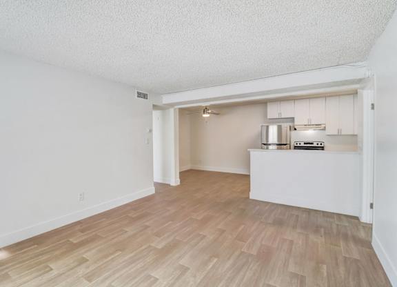 A room with a kitchenette in the middle of it.