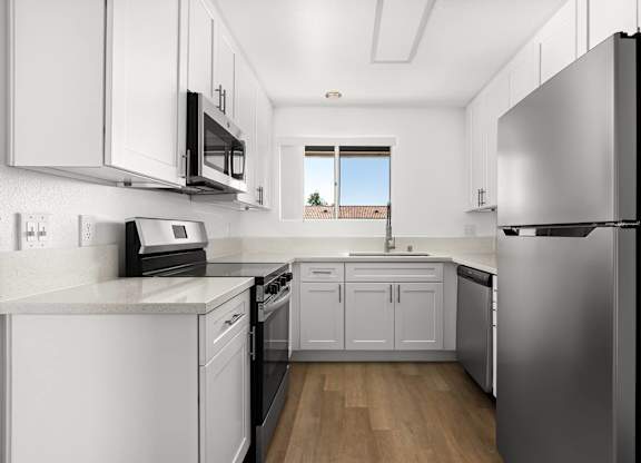 A modern kitchen with stainless steel appliances and white cabinets.