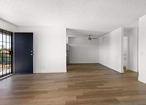 A room with a dark blue door and wooden flooring.