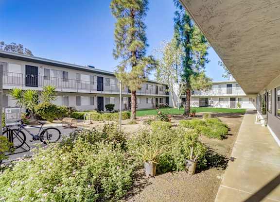 A sunny day at a residential complex with a bicycle parked on the left.
