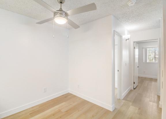 A room with a ceiling fan and light fixture.