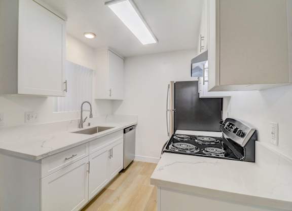 A kitchen with white cabinets and a black stove top oven.