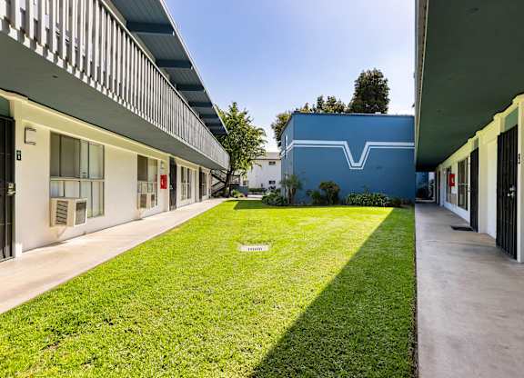 A long grassy area separates two buildings.