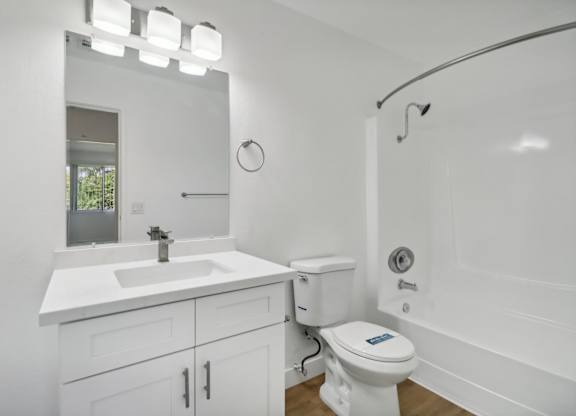 A white bathroom with a sink, toilet, and bathtub.
