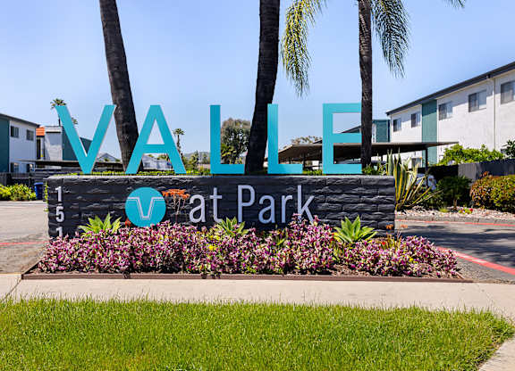 A sign that says "Vallarta Park" in front of some buildings.