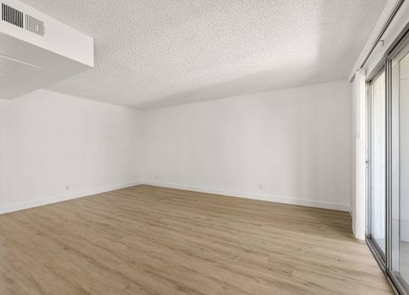 A room with wooden flooring and white walls.