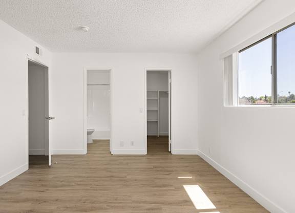 A large empty room with a toilet in the middle.