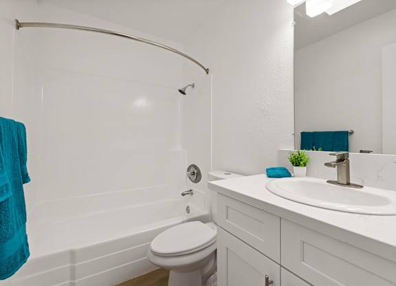 A white bathroom with a white toilet and a white sink.
