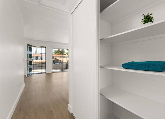 A white shelf with a blue towel on it.